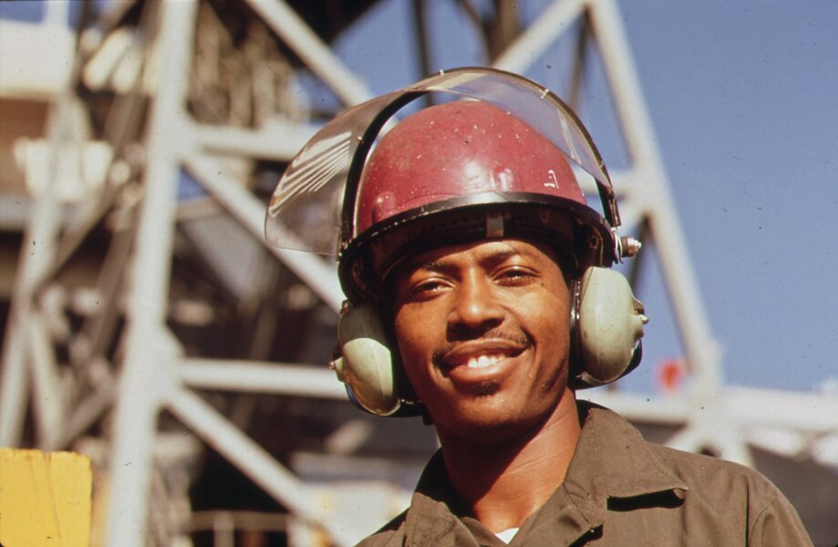 AVONDALE_SHIPYARD_WORKER_WEARS_SPECIAL_EAR_MUFFS_FOR_PROTECTION_FROM_THE_HEAVY_LEVEL_OF_INDUSTRIAL_N