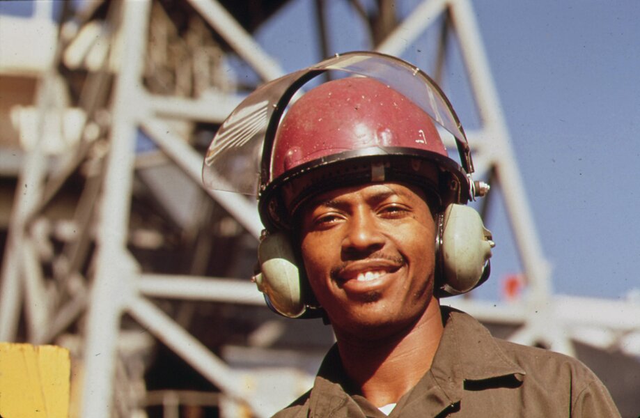 AVONDALE_SHIPYARD_WORKER_WEARS_SPECIAL_EAR_MUFFS_FOR_PROTECTION_FROM_THE_HEAVY_LEVEL_OF_INDUSTRIAL_N
